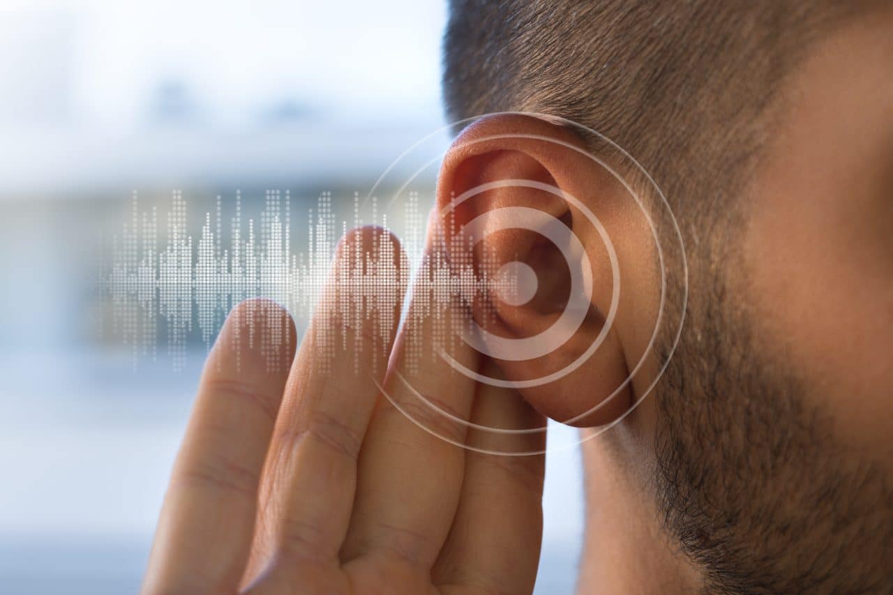 close-up image of a man touching his ear