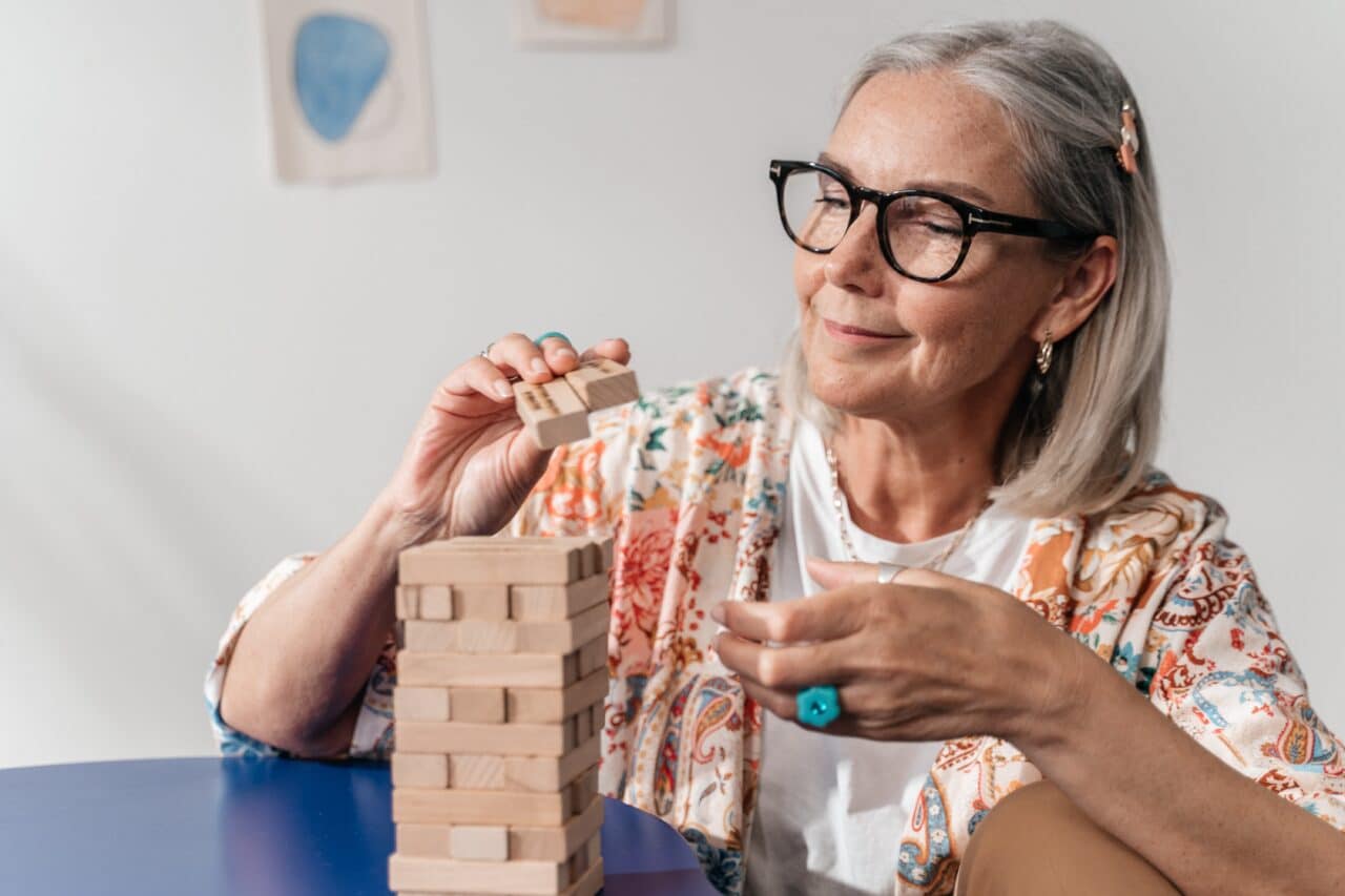 Senior woman working on a puzzle at home.