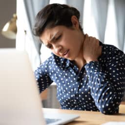 Woman holding neck experiencing Fibromyalgia pain