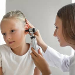 Girl gets ear examined by doctor