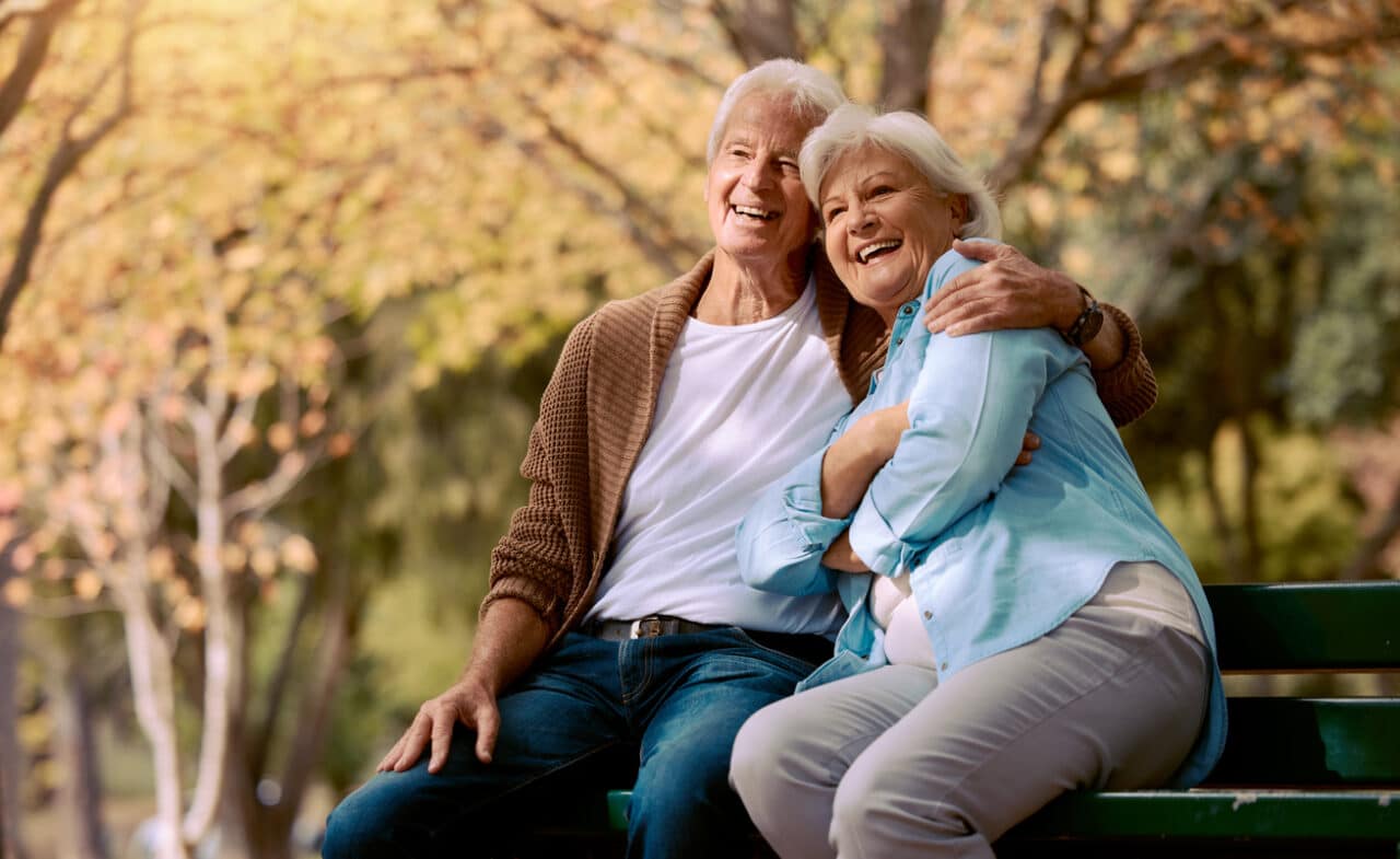 Happy couple on a bench enjoying the weather.